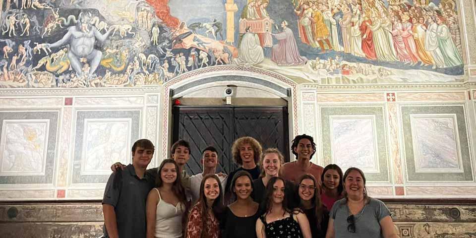 一群学生在意大利的一幅壁画前.